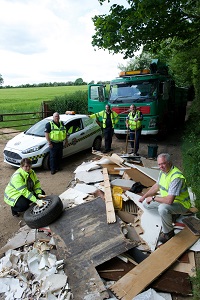 Uniformed officers dealing with flytipping on country road