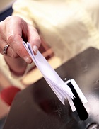 Woman putting voting papers into ballot box