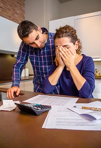Couple looking at household bills and looking worried