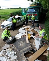 Uniformed officers dealing with flytipping on country road