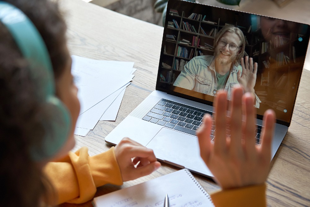 Teen on laptop speaking to a teacher