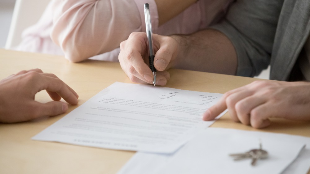 People signing an agreement for home keys