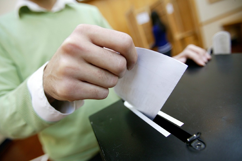 Person putting ballot paper in ballot box