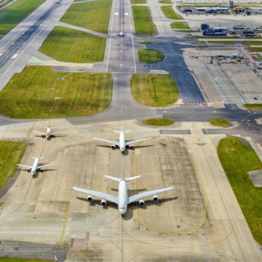 Photo of airport runways from above with four airplanes waiting on the tarmac