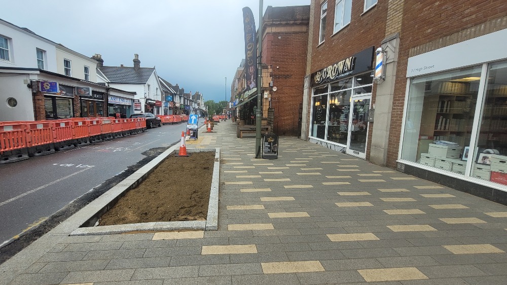 The widened, paved pavements and flower beds on Horley high street 