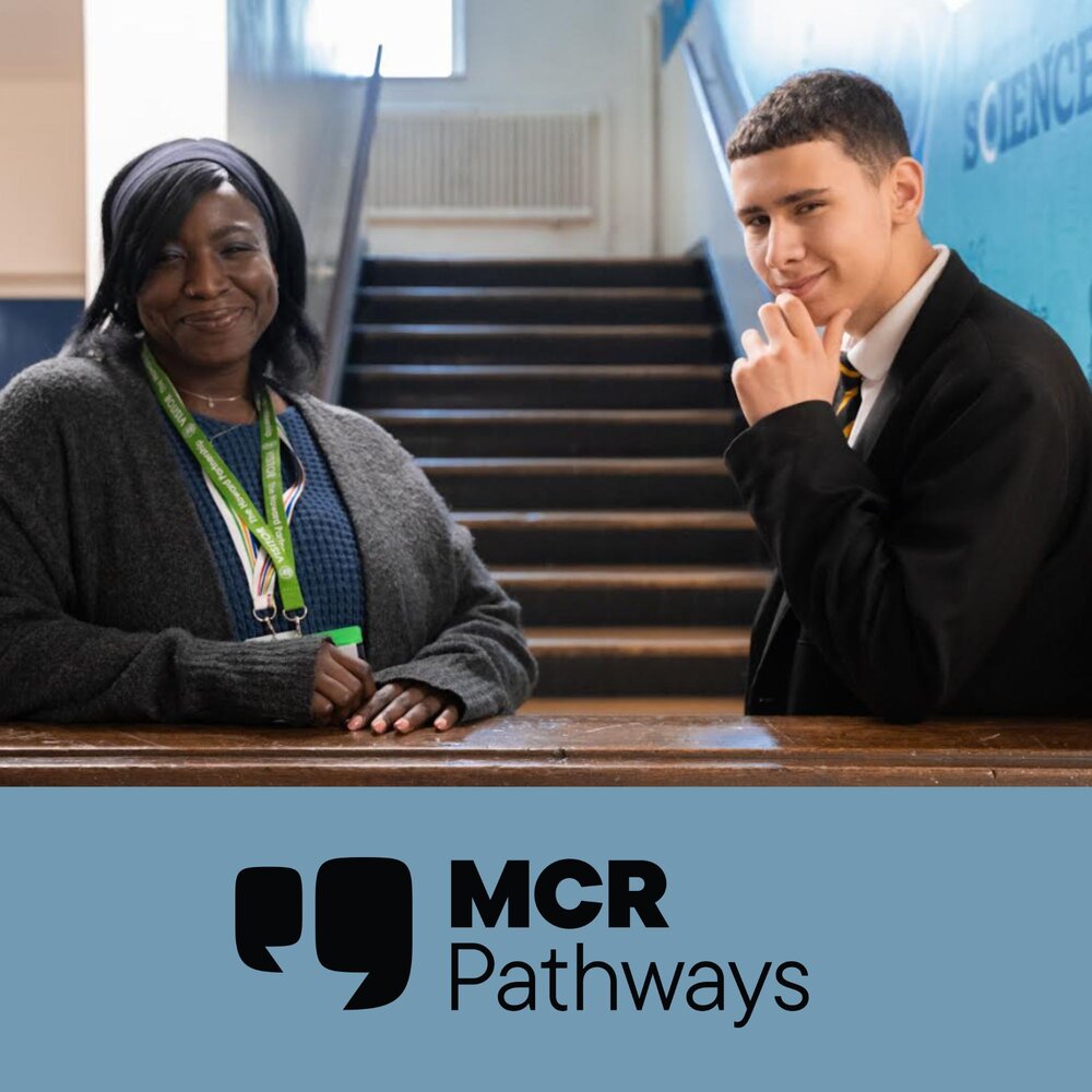 An adult and a student stand talking beside a wooden railing in a school hallway, with a staircase in the background. The adult wears a lanyard and a dark cardigan, while the student is dressed in a school uniform. Below the image is the MCR Pathways logo on a light blue background
