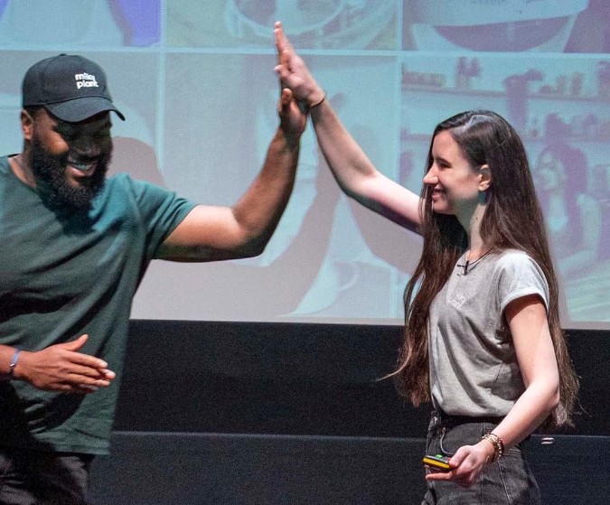 Photo of two people high fiving infront of a projector
