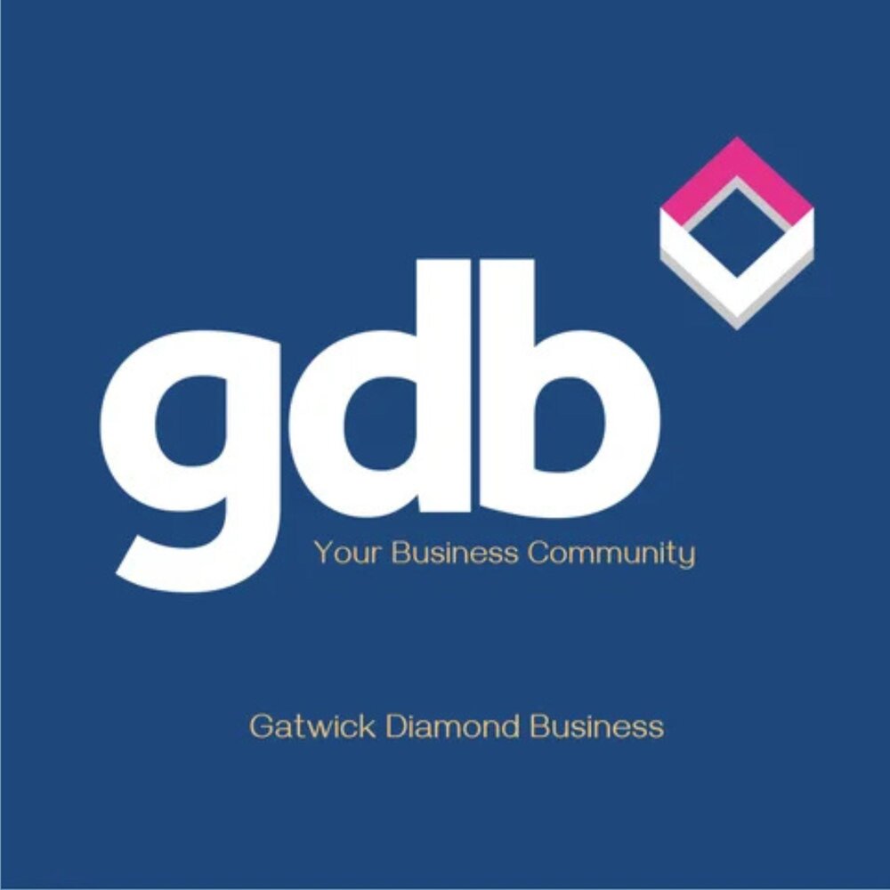 Logo for Gatwick Diamond Business (gdb) on a dark blue background. Large white lowercase letters ‘gdb’ appear with the tagline ‘Your Business Community’ beneath. At the top right is a geometric diamond‑shaped icon in pink, grey and white. The words ‘Gatwick Diamond Business’ appear at the bottom in small gold text.”